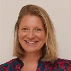 Smiling woman with blonde hair in patterned blouse, supporting youth advocacy, photographed in Leeds for Doing Good Leeds.